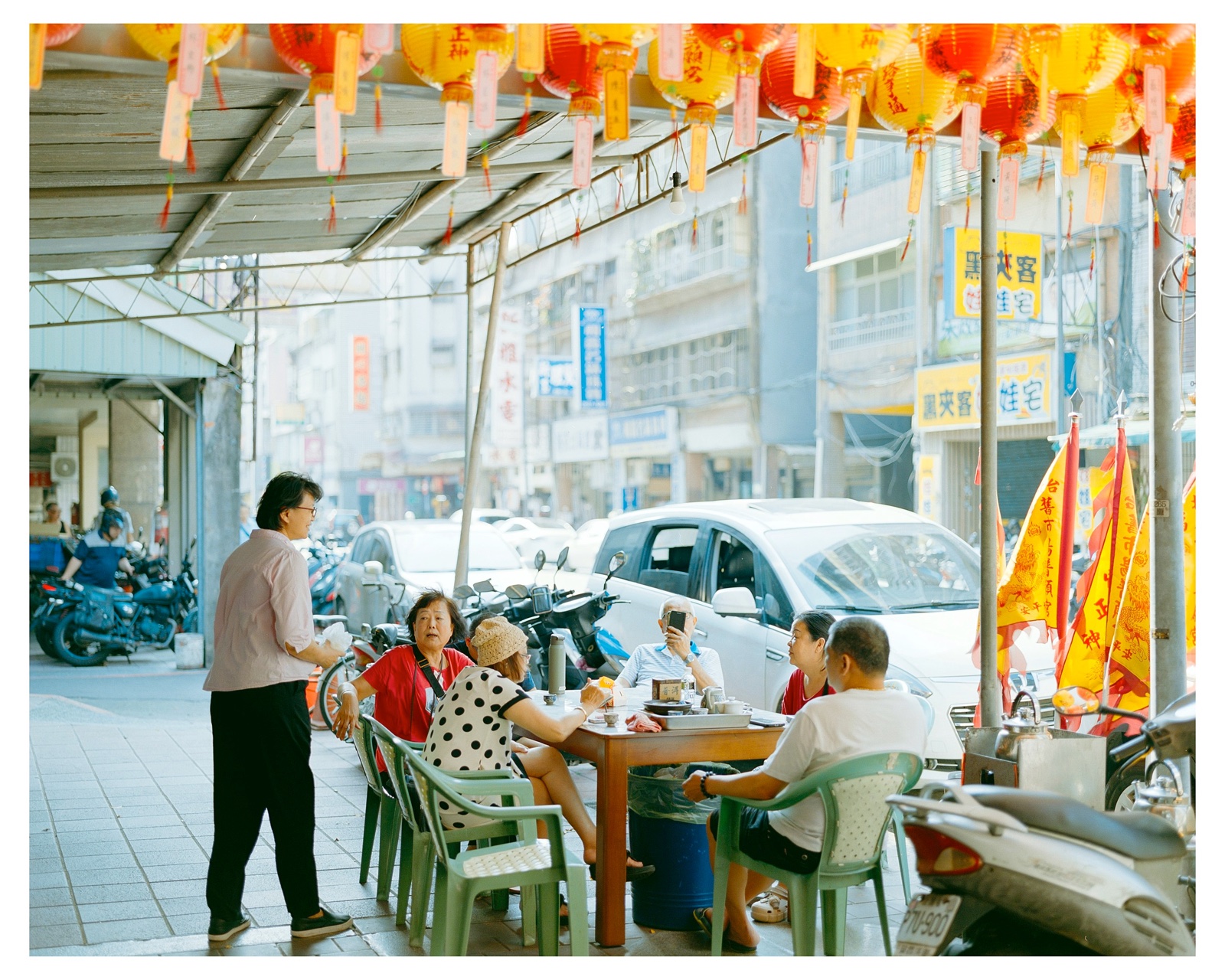 灯笼下，几个人围坐在街边喝茶